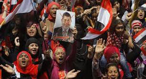 Il volto di Mohammed Morsi obliterato nei cartelli della protesta di Piazza Tahrir.